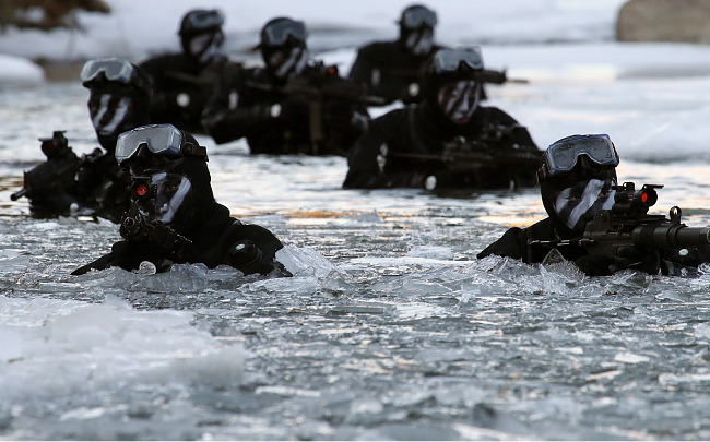 육군 특전사령부 장병들이 얼음물을 헤치며 수중침투훈련을 하고 있다. [동아일보]