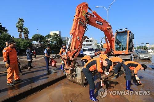 <태풍 차바> '복구가 최우선' (제주=연합뉴스) 박지호 기자 = 제18호 태풍 차바가 제주를 통과한 5일 오후 민·관·군 봉사자들이 제주시 용담로 침수 피해 지역에서 복구작업을 하고 있다. 2016.10.5 jihopark@yna.co.kr