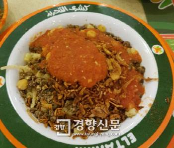 병아리콩, 렌틸콩, 쌀, 마카로니에 양파, 토마토소스를 얹어 먹는 코샤리.