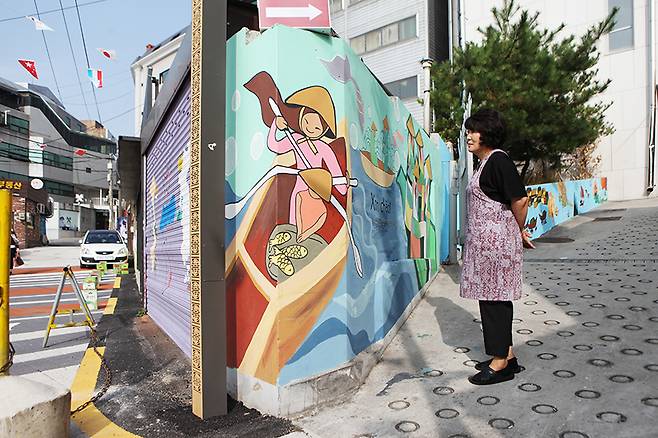 이태원의 ‘베트남 퀴논 길’를 걸으면 자연스럽게 베트남 문화를 만날 수 있다. 베트남 전통 의상을 입은 여인이 등장하는 벽화 옆 조명 기둥에는 베트남 전통 문양이 새겨져 있다. 장수선 기자