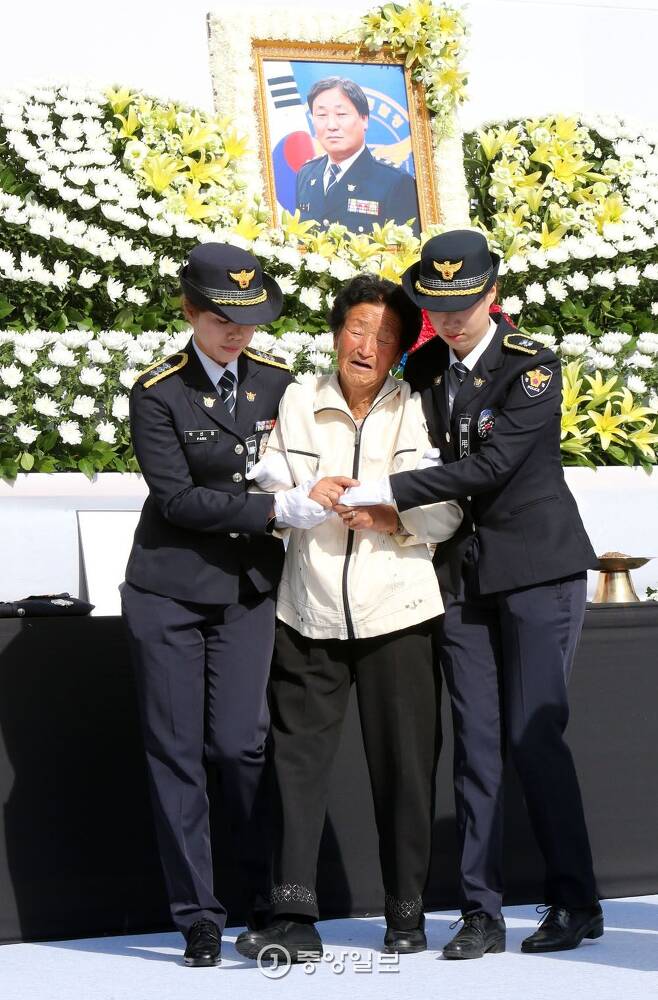 고(故) 김창호(54) 경감의 어머니가 경찰관의 부축을 받으며 헌화한 뒤 자리로 돌아가고 있다. 조문규 기자