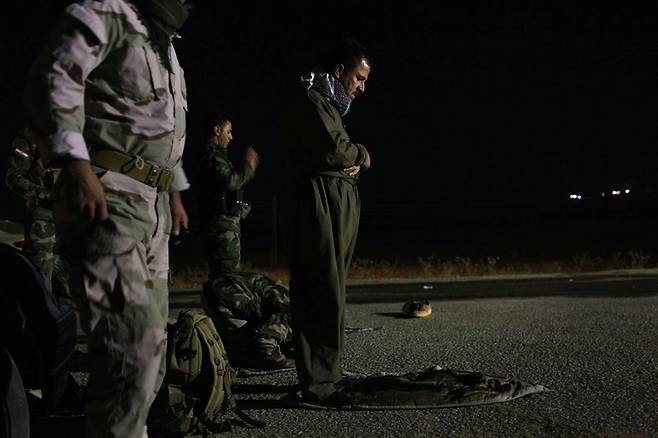 20일 새벽 이라크 모술 인근의 최전선에서 쿠르드민병대(PAK) 대원들이 이슬람국가(IS)와의 전투를 앞두고 기도하고 있다.