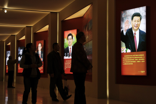 중국 공산당 18기 중앙위원회 6차 전체회의(6중전회)가 24일 개막된 가운데 베이징 군사박물관에서 관람객들이 중국 공산당 대장정 80주년 관련 전시회에 걸린 역대 중국 국가주석들의 사진을 보고 있다. 오른쪽부터 시진핑, 후진타오, 장쩌민, 덩샤오핑, 마오쩌둥. AP연합뉴스