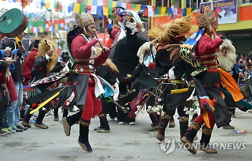 22일 인도 동북부 아루나찰 프라데시 주에서 열린 타왕축제에서 전통의상을 입은 이들이 춤을 추고 있다.[AFP=연합뉴스 자료사진]