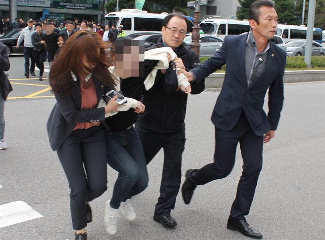 27일 오전 11시 40분쯤 부산 해운대구 벡스코 제2전시장 입구에서 “대통령은 하야하라”며 기습 시위를 벌인 대학생이 경찰에 끌려가고 있다.