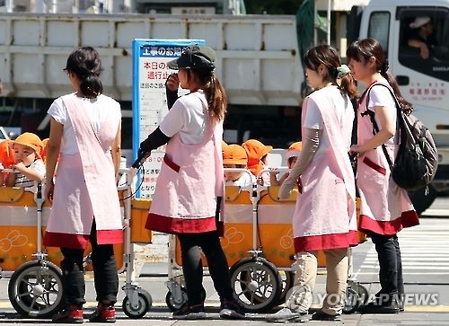 2016년 9월 1일 일본 도쿄도의 거리에서 보육사들이 보육원에서 돌보는 어린 아이들을 손수레에 태우고 나왔다. 일본은 저출산 고령화 문제를 해결하기 위해 출산을 장려하고 있으나 보육원(보육소) 부족이 걸림돌로 여겨진다. 일본 정부는 일과 자녀 양육을 병행할 수 있는 환경을 만드는 것을 중요 정책 목표로 삼고 있다. [촬영 이세원]