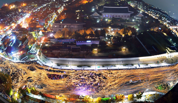 박근혜 대통령 퇴진을 촉구하는 3차 촛불집회에 참여한 100만 시민의 촛불이 서울 경복궁 앞 도로를 가득 메우고 있다. 촛불의 흐름과 청와대 전경을 다중촬영해 합성했다.사진공동취재단