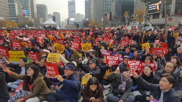 박근혜 대통령 퇴진을 요구하는 시민들이 19일 서울 광화문광장에서 열린 4차 촛불집회 사전 행사에 참가해 '박근혜는 하야하라' '퇴진하라'고 적힌 피켓을 들고 있다. 신지후 기자
