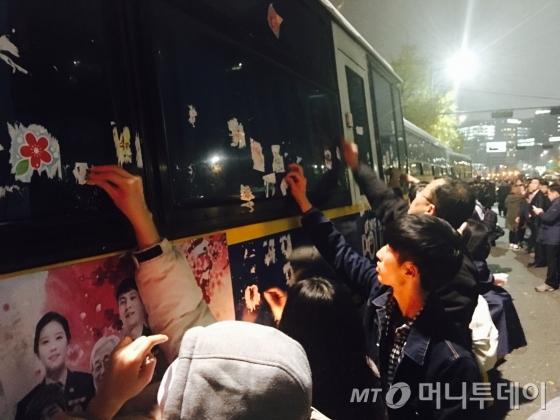 19일 밤 서울 종로구 내자동 로터리 인근에 설치된 차벽에 붙은 스티커를 시민들이 촛불집회가 끝나가자 자발적으로 제거하고 있다. /사진=김평화 기자