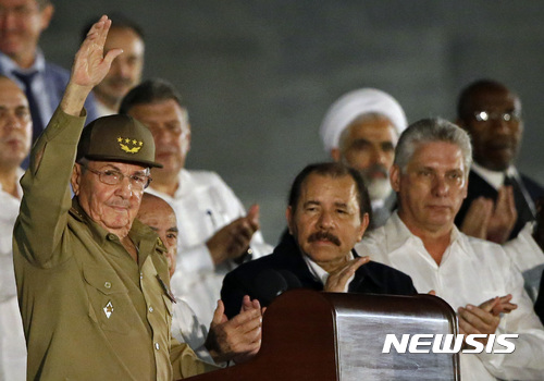 【아바나=AP/뉴시스】라울 카스트로 쿠바 국가평의회 의장이 29일 아바나에서 열린 피델 카스트로 전 의장 추도행사에 참석해 손을 들어 보이고 있다.오른쪽에 서있는 사람은 다니엘 오르테가 니카라과 대통령이다.  2016.11.30