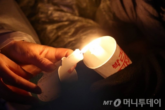 26일 서울 광화문 일대에서 열린 5차 촛불집회 당시 참가자들이 서로 촛불을 나눠 붙이고 있다./ 사진=임성균 기자