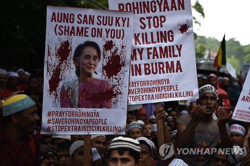 지난달 25일 말레이시아에서 열린 로힝야족 학살 반대 집회에서 참가자들이 붉은 페인트를 칠한 미얀마의 실권자 아웅산 수치의 사진을 들고 있다.