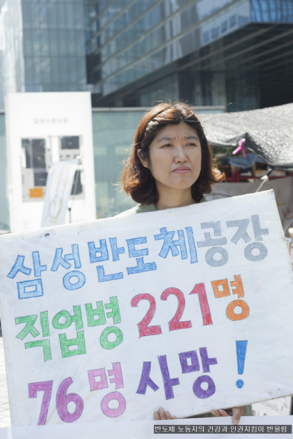 지난 9월, 이종란 활동가가 반올림 농성장 앞에서 열린 기자회견에 참석해 삼성 반도체 직업병으로 피해를 보고 사망한 노동자의 숫자를 알리는 피켓을 들고 서 있다. /반올림 제공