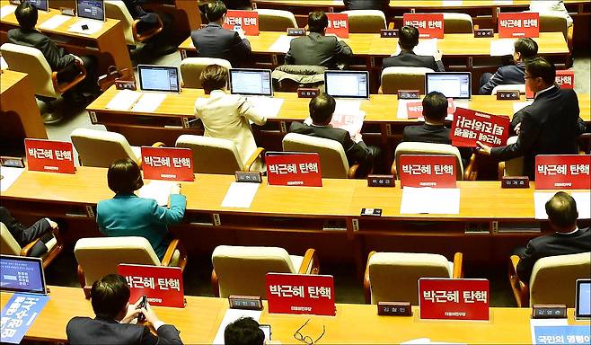 박근혜 대통령의 탄핵소추안 국회 본회의 처리를 하루 앞둔 8일 탄핵소추안 보고를 위해 열린 국회 본회의를 앞두고 더불어민주당 의원들이 박근혜 대통령 탄핵 촉구 손팻말을 모니터에 붙이고 있다. ⓒ데일리안
