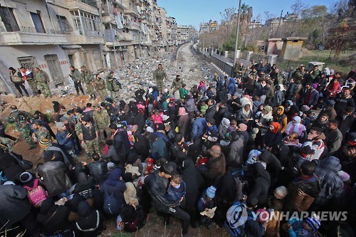 8일 알레포 피난민들이 마이살룬 구역 검문소에서 시리아군의 통제에 따라 모여 있다.[AFP=연합뉴스]