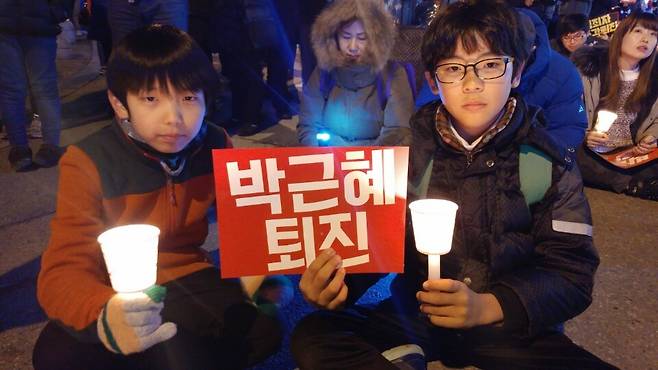 단짝인 이현수·강승우(10) 군이 10일 저녁 ‘4차 대전 10만 시국대회’에 참석해 촛불을 들고 박근혜 퇴진을 요구하고 있다.