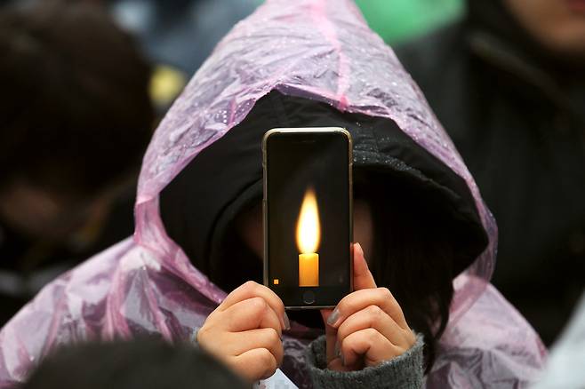 지난 11월 26일 집회에 참여한 시민이 촛불그림을 띄운 스마트폰을 들고 구호를 외치고 있다. [사진=중앙포토]