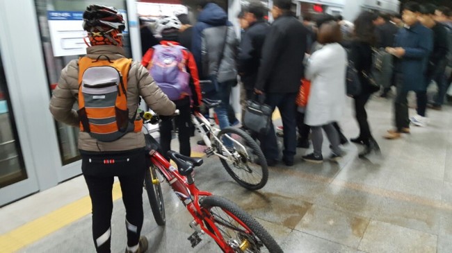 [사진=평일 퇴근 시간대에 한 승객이 자전거를 끌고 지하철 개찰구를 지나가려고 하는 중이다. 명백한 규정 위반이지만 직원에게 적발돼도 내야하는 부가금은 900원 남짓밖에 되지 않는다. 사진은 용산역에서 자전거를 휴대하고 1호선 전동차에 탑승하고 있는 모습.]
