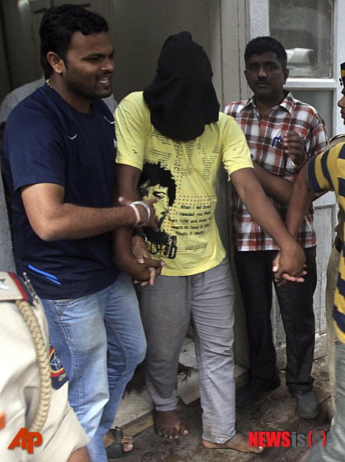 【뭄바이=AP/뉴시스】인도 경찰이 25일 여성 사진기자를 집단 강간한 혐의자 다섯 명 중 한 명을 법정에 출두시킨 뒤 검은 천으로 얼굴을 가려 밖으로 데리고 나오고 있다. 경찰은 다섯 명 모두를 체포했다고 말했다. 2013. 08. 25