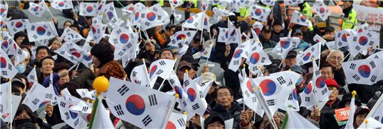 6일 서울 용산구 전쟁기념관 앞에서 열린 탄핵반대 집회에서 참석한 시민단체 회원들이 태극기를 흔들고 있다. / 사진=연합뉴스
