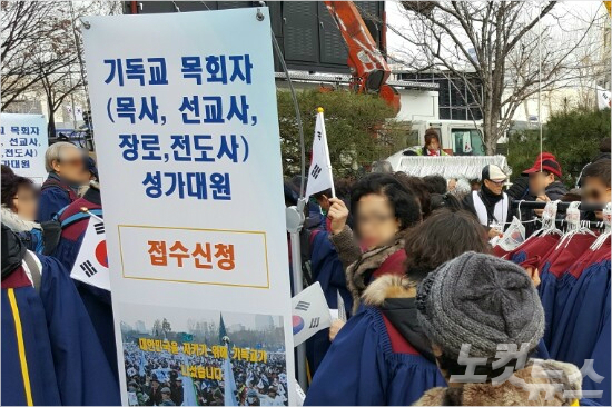 지난 7일 삼성동에서 열린 탄핵반댇집회에서 주최측이 목회자, 성가대 가운을 빌려주고 있다.