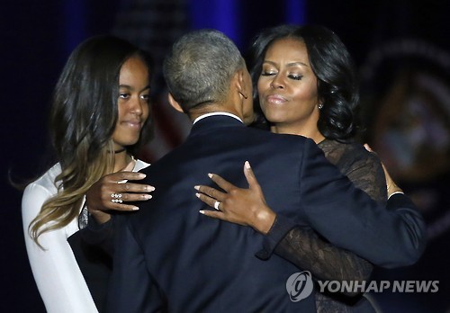 버락 오바마 미국 대통령이 10일(현지시간) 시카고 대형 컨벤션센터 매코믹 플레이스에서 고별 연설을 마친 뒤 딸 말리아가 지켜보는 가운데 아내 미셸 여사와 포옹하고 있다.[AP=연합뉴스]