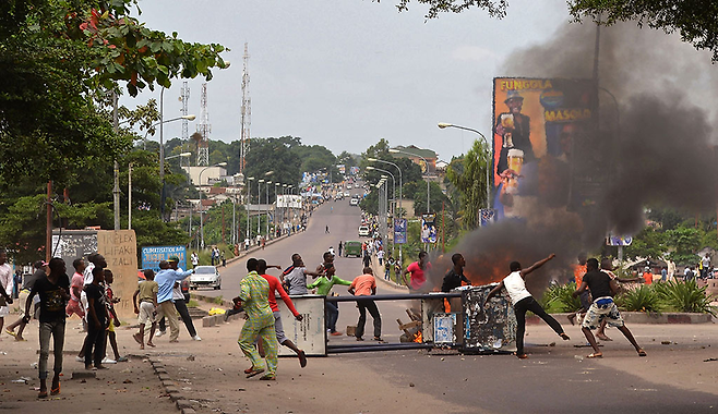 2015년 1월19일 콩고민주공화국 킨샤샤에서 반정부 시위대가 도로를 막은 채 타이어를 태우고 있다. 이날 시위대는 2016년 대통령·의원 선거를 앞두고 인구 총조사 실시를 포함한 선거법을 제정해 조셉 카빌라 대통령의 집권을 연장하려는 움직임에 항의하는 시위를 벌였다. ⓒ AP연합