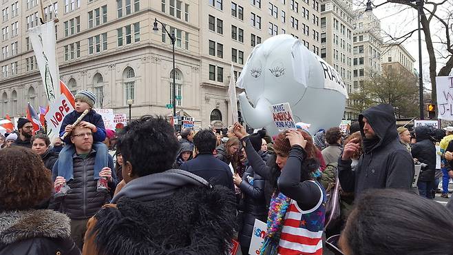 20일 오후 트럼프 반대 집회 참석자들이 바람을 넣은 코끼리상에 인종차별주의자는 구호를 붙인 채 운반하고 있다.