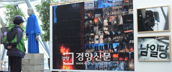 용산참사 8주기를 하루 앞둔 1월 19일, 한 시민이 서울 중구 세종대로 서울시청 1층 로비에 전시된 용산참사 관련 전시물을 보고 있다. 김창길 기자