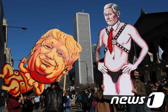 미 시카고에서 21일 시위대가 도널드 트럼프 대통령과 마이크 펜스 부통령을 풍자한 그림을 이용해 반(反) 시위를 벌이고 있다.© AFP=뉴스1