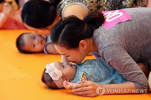 2014년 서울에서 열린 '건강한 모유수유아 선발대회'에서 아기 올림픽 뒤집기 종목에 출전한 한 아이가 엄마와 입을 맞추고 있다. [사진은 기사 내용과 직접적인 연관은 없음]