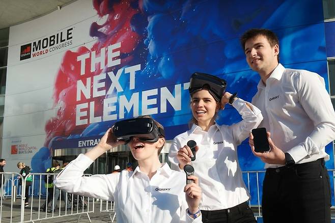 26일 삼성전자 모델들이 스페인 바르셀로나의 모바일월드콩그레스(MWC) 전시장 앞에서 기어브이아르(VR) 신제품, 2017년형 갤럭시A 스마트폰, 스마트워치 기어S3를 보여주고 있다. 삼성전자 제공