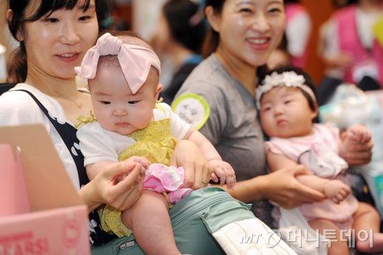 5일 낮 대구 수성구 호텔인터불고대구에서 열린 '건강한 모유수유아 선발대회 제11회 대구대회'에 참가한 아기들이 차례를 기다리며 엄마품에 안겨 있다. 2016.7.5/뉴스1 <저작권자 © 뉴스1코리아, 무단전재 및 재배포 금지>