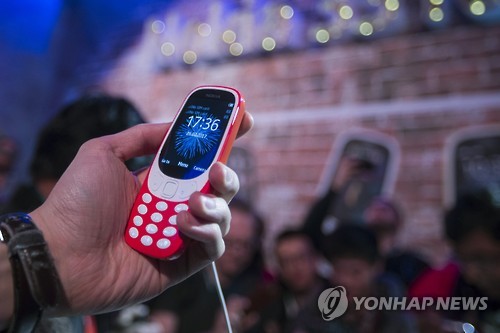 epa05816824 A visitor takes a close look at the new Nokia 3310 during its presentation on the eve of the opening of Mobile World Congress (MWC) in Barcelona, northeastern Spain, 26 February 2017. The congress under the motto 'The next element' runs from 27 February to 02 March 2017.  EPA/QUIQUE GARCIA