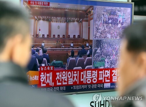 (대전=연합뉴스) 양영석 기자 = 10일 대전역 대합실에 모인 시민들이 박근혜 대통령 탄핵 인용 소식을 전하는 뉴스 보도를 바라보고 있다.  youngs@yna.co.kr