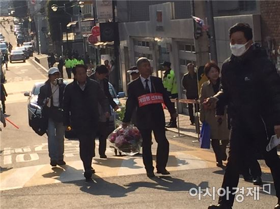 한성주 공군 예비역 소장이 박근혜 전 대통령 자택 100m 앞에서 시위를 마치고 박 전 대통령에게 꽃을 전달하러 가고 있다.