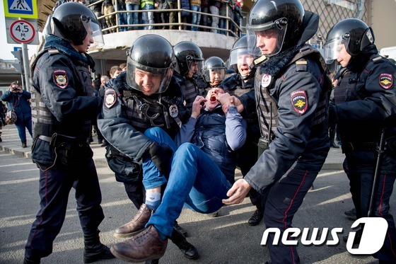 26일(현지시간) 러시아 수도 모스크바에서 열린 '반(反)부패 시위'에 참가했던 시민이 경찰에 의해 실려나가고 있다. © AFP=뉴스1
