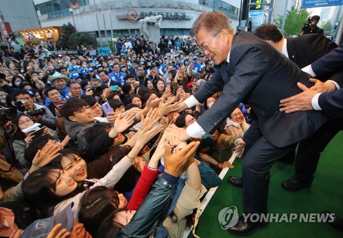 지난 18일 광주 충장로에서 열린 집중유세에서 지지자들과 손을 잡으며 인사하고 있는 문재인 더불어민주당 대선후보 [연합뉴스 자료사진]