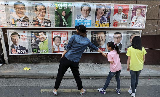 제19대 대통령 선거가 16일 남겨진 23일 서울 관악구 미성동 주택가 한 골목에서 한 가족이 15명의 후보가 출마한 대톨령 선거 포스터를 보고 있다. ⓒ데일리안 박항구 기자