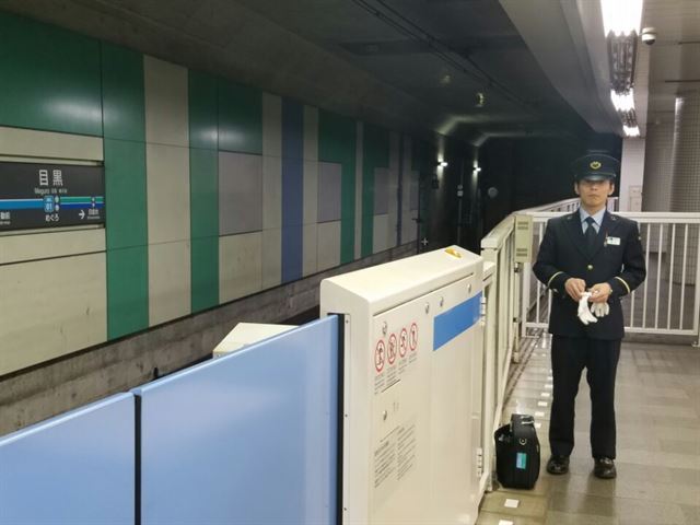 일본에서 전철 내 성추행 의심범이 선로로 뛰어내려 도주하는 사례가 늘고 있는 가운데, 도쿄 시내 지하철 메구로역에서 한 역무원이 들어오는 열차를 바라보며 서 있다. 한국일보 자료사진