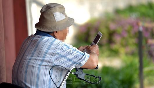 한 노인이 홀로 핸드폰을 만지고 있다. [사진=헤럴드경제DB]