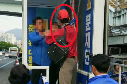 지난 26일 오후 미국 국적 정모(54)씨가 부산시 부산진구 가야1치안센터 앞에 서 있던 문재인 더불어민주당 후보 유세 지원차량에 올라 민주당 관계자의 멱살을 잡고 있다. /부산경찰청 제공