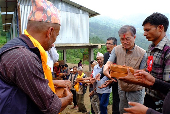 지난해 6월 네팔을 방문한 문재인 대통령(오른쪽에서 두 번째)이 현지인들과 줄지어 서서 벽돌을 나르고 있다. 사진은 당시 안내를 맡은 박타 람 라미차네 씨의 페이스북 사진.
