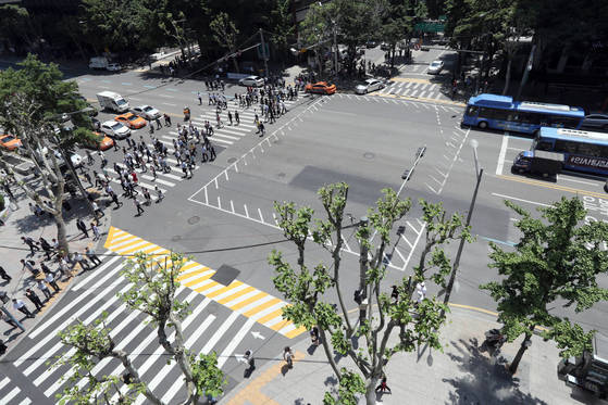 서울 종로구청 앞 네거리(왼쪽)의 ‘ㄷ자’ 횡단보도는 돌아서 건너려면 1분39초가 걸린다.[최정동 기자]