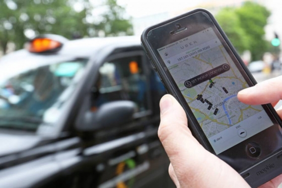 승차 서비스 고객이 차량공유서비스업체 우버(Uber)의 어플리케이션을 이용하는 모습/사진=블룸버그
