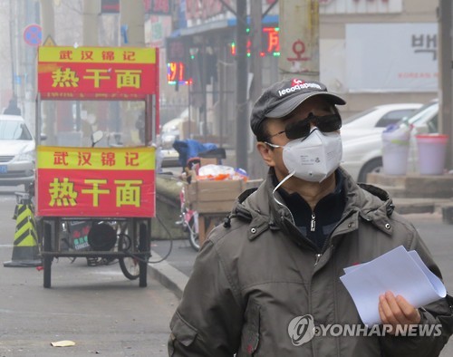 작년 12월21일 중국 랴오닝성 선양시에 심각한 수준의 스모그가 발생한 가운데 한 남성이 마스크를 착용하고 시타 거리를 걷고 있다.