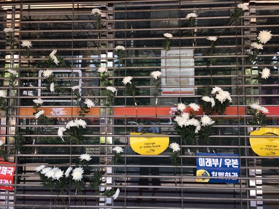 18일 오후 서울 광화문우체국에 집배노조원들이 죽은 동료 노조원들을 추모하며 남기고 간 국화들. 홍상지 기자