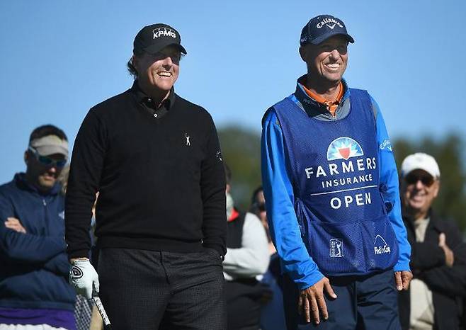필 미컬슨(왼쪽)이 자신의 캐디 짐 매케이와 지난 1월 27일(현지시간 미국 캘리포니아주 샌디에이고의 토레이 파인스 사우스코스에서 열린 미국프로골프(PGA) 투어 파머스 인슈어런스 오픈 2라운드 2번홀 티잉 그라운드에서 미소짓고 있다.(사진=AFPBBNews)