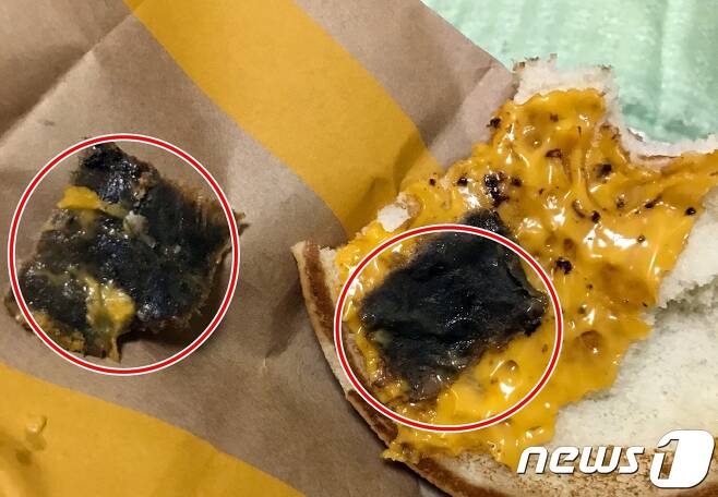 지난 21일 밤제주에 있는 한 맥도날드 매장에서 판매된 햄버거에 검게 변색된 500원짜리 크기의 종이  (동그라미 안)로 추정되는 이물질이 발견됐다.(사진=제보자 제공) © News1