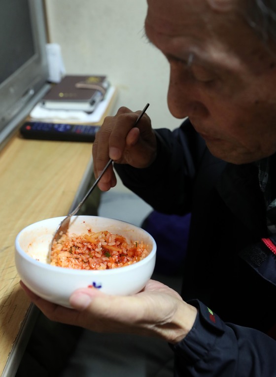 서울 은평구 김병국(82) 할아버지가 고시원 쪽방에서 김치 한 가지로 혼자 점심을 먹고 있다. 김씨는 자식이 있다는 이유로 기초수급자 보호를 못 받고 있다. [중앙포토]